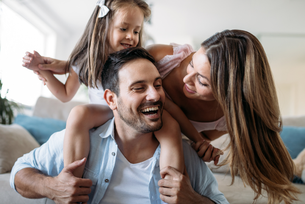 Family playing together smiling with healthy teeth Woodlands TX dental care