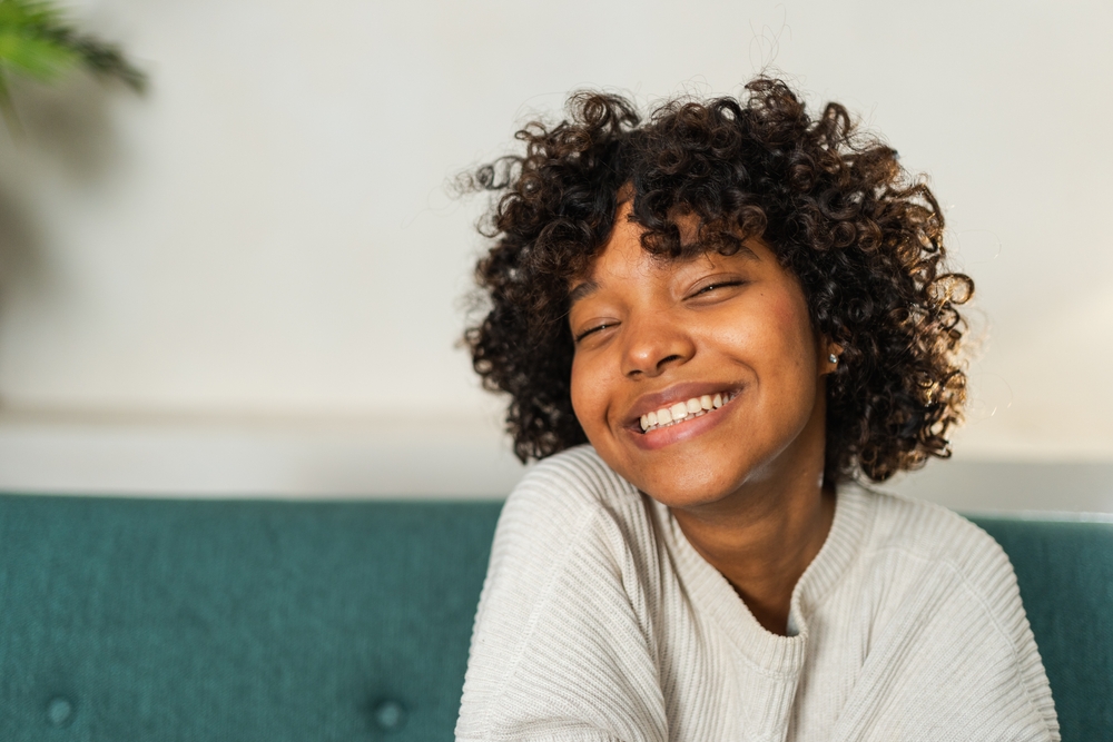 Happy woman with curly hair smiling after Gum Disease Treatment The Woodlands TX