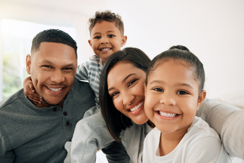 Father and children smiling bright healthy smiles The Woodlands TX dentist