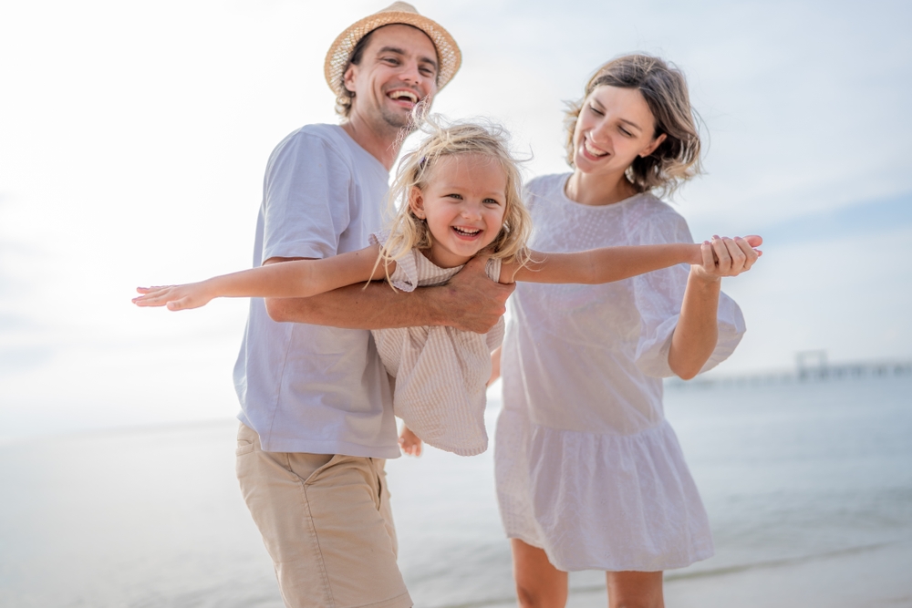 Happy family playing together smiling healthy teeth Woodlands TX dental care