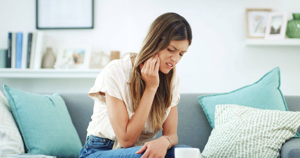 Woman experiencing tooth pain needing emergency dentist The Woodlands TX