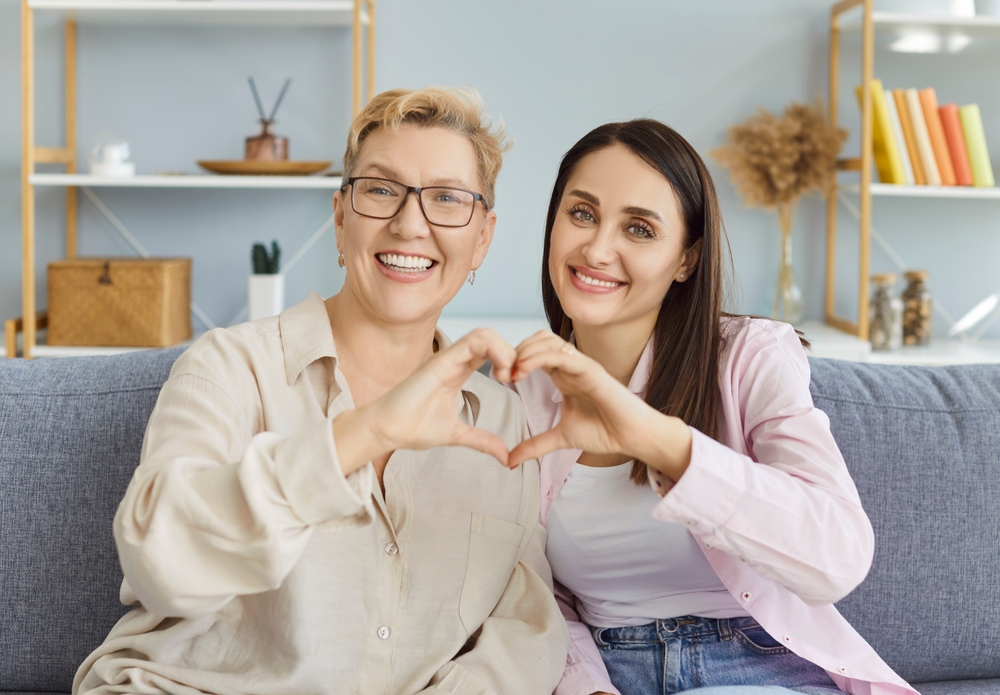 Two women making heart shape smiling healthy teeth after Oral Cancer Screening in Woodlands TX dental care