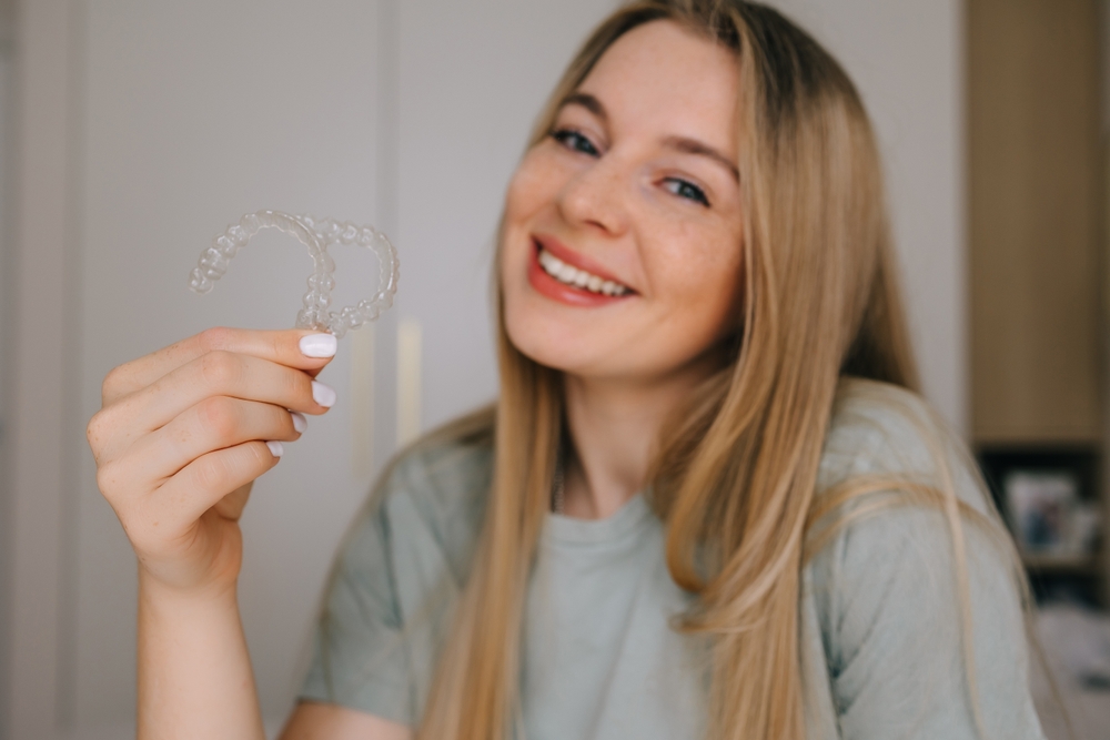 Young woman showing clear aligners orthodontic care Woodlands TX