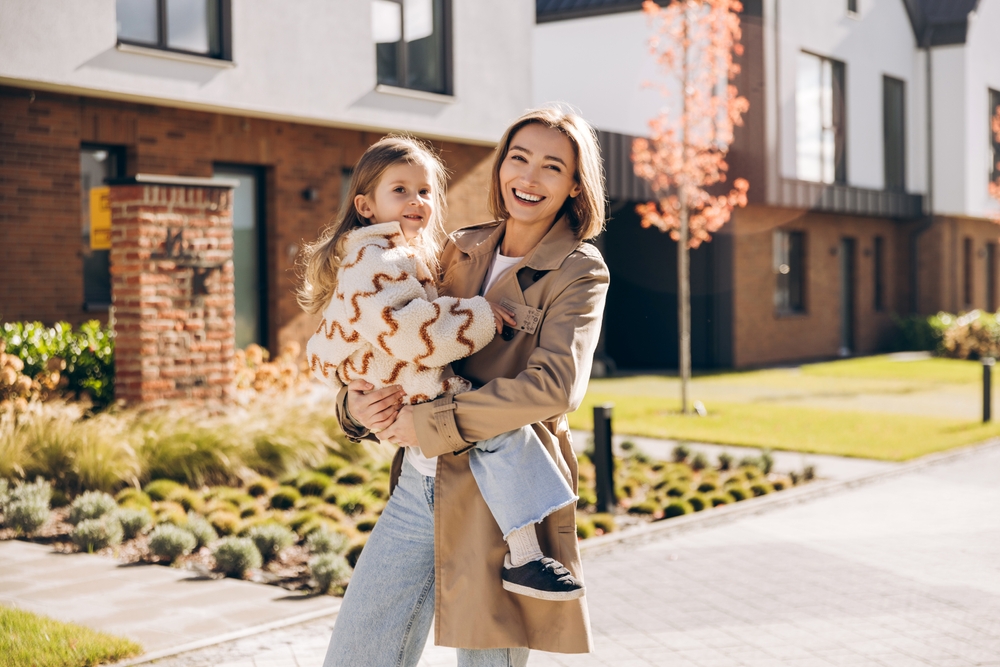 Mother holding child smiling outside family dental care and Orthodontics in The Woodlands TX
